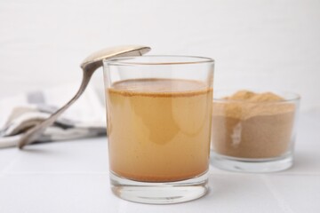 Soluble fiber with water in glass and powder on white table
