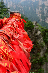 Red blessing ribbons and love locks line handrails in Zhangjiajie National Forest Park in Wulingyuan Scenic Area, China.