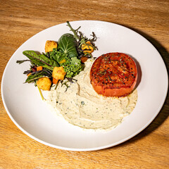 Salad with sour cream and baked tomato. Hotel restaurant. Gastronomy.
