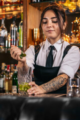 Female bartender preparing a cocktail in a traditional cocktail bar