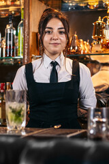 Portrait of a young female bartender in a traditional cocktail bar