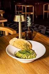 Green pasta with parmesan cheese and spiced bread. Pesto and spinach. Gourmet hotel restaurant.