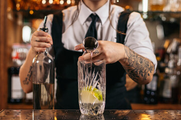 Female bartender preparing a cocktail in a traditional cocktail bar