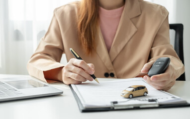 Car dealer businesswoman signing car insurance document or lease paper. Car loan and insurance concept