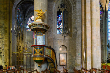 Interior view of the nave, pulpit, colonnades and stained glass windows inside the medieval Basilique Saint Nazaire, in La Cite' inside the castle at Carcassonne, France.