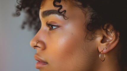Close-up side profile of woman with curly hair and earrings - obrazy, fototapety, plakaty