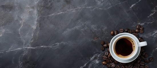 Steaming black coffee in a cup placed on a rugged stone surface