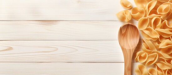 A rustic wooden spoon resting beside a bunch of pasta on a clean white wooden table - Powered by Adobe