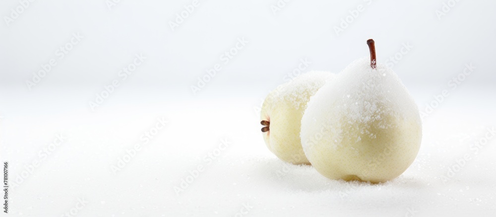 Poster A pair of ripe pears lay gently on a blanket of white snow, showcasing tranquility and simplicity in nature