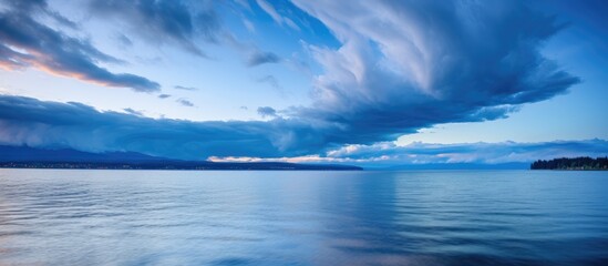 Fototapeta premium The tranquil lake is under the watchful eye of a prominent cloud in the sky