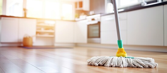 Man cleaning the kitchen floor with a mop, focusing on the wooden surface