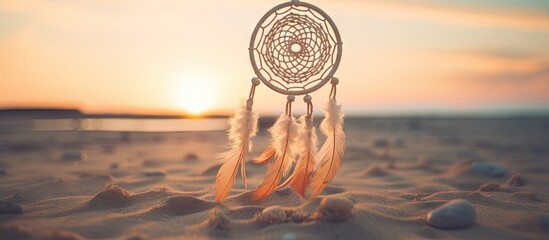 Dream catcher hanging at the beach during sunset, surrounded by shells on the sand - obrazy, fototapety, plakaty