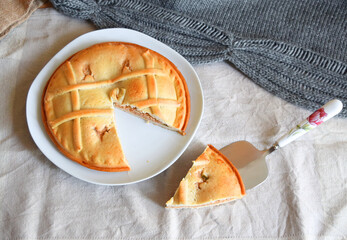 Freshly cut round empanada on natural fabrics background