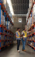 A group of warehouse employees, Inspecting products on warehouse shelves before they are sent to...
