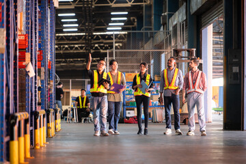 A group of warehouse employees, Inspecting products on warehouse shelves before they are sent to...