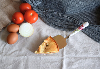 Piece of freshly baked empanada on natural fabric background along with fresh food