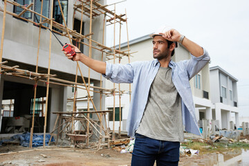 worker or architect using walkie talkie and talking to someone at construction site