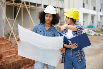 workers or architect holding plan blueprint paper at construction site