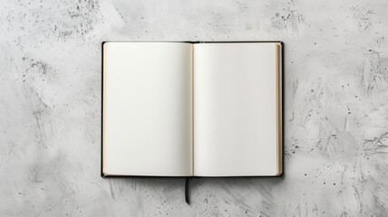Open blank book lies on textured grey surface, offering clean slate for writing or drawing