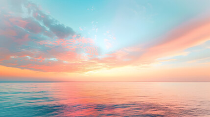 A beautiful sunset over the ocean with a few clouds in the sky. The sky is a mix of pink and blue colors