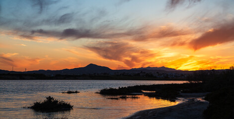 Vibrant sunset over salt lake in Cyprus Larnaca in spring with orange sky and clouds
