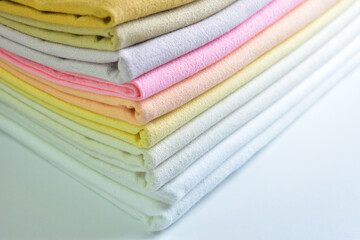 stack of colourful cotton clothes, pile of clothing on white background - 781031312
