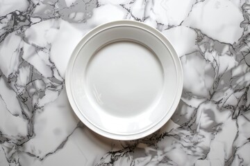Obraz na płótnie Canvas Overhead view of a white plate resting on a luxurious marble counter