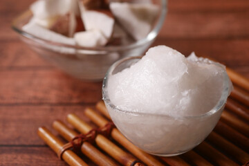 slice of fresh coconut and bottle of oil on a table 