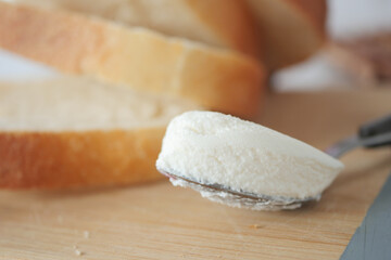 Slice of bread and cream cheese on white background.