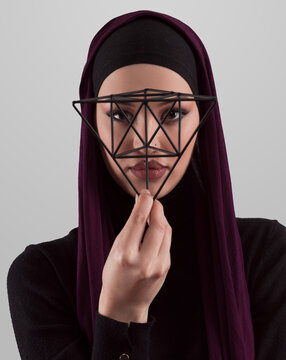Muslim woman wearing modern stylish wear and hijab isolated on grey background. Diverse people model hijab fashion concept. Face recognition and biometric data identify face science.