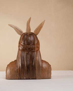 Carved wood sculpture of the Inca hero Atahualpa on a brown background. Andean sculpture. Craft. Latin American culture.