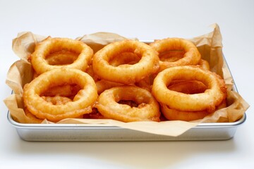 Obraz na płótnie Canvas Onion rings piled on a rectangular metal tray with brown craft paper isolated on white background.
