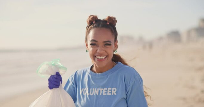 Woman, volunteer and face on beach with plastic bag for cleaning garbage, community service or sustainability. Female person, smile and trash recycling for climate change, planet or waste management