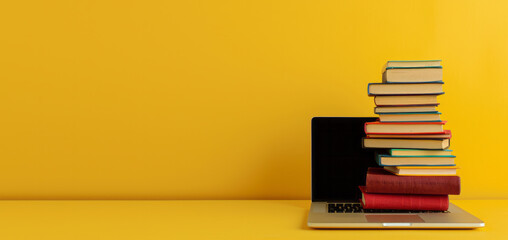 Fototapeta premium Modern open laptop lies on books on the table on a yellow background, back to school concept, distance learning, work online, freelancing, copy text