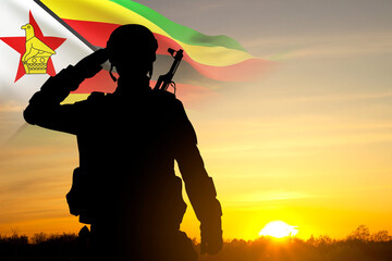 Silhouette of a saluting soldier with Zimbabwe flag against the sunset - obrazy, fototapety, plakaty