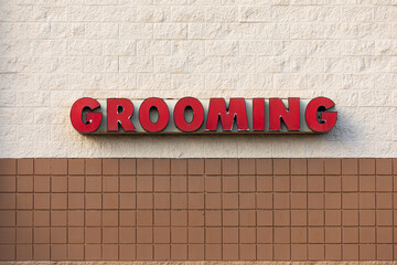 Red grooming sign on a wall of a famous pet store building 