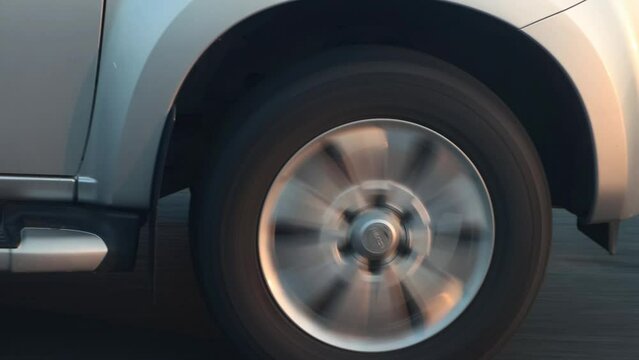 Rotating wheel of a car driving on the highway in the early evening