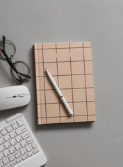 Work, learning background - keyboard, mouse, notepad, glasses on a gray background, top view
