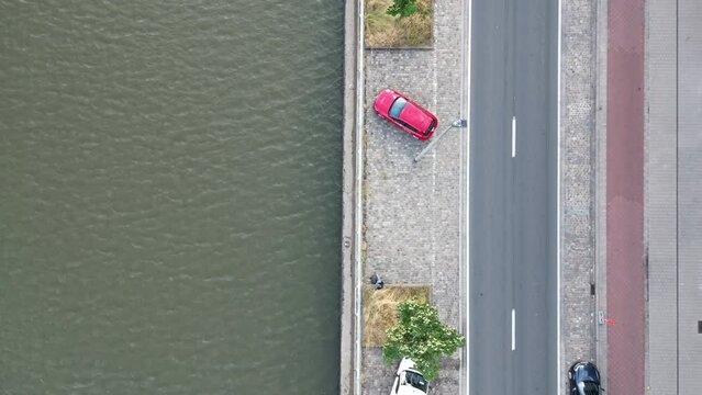 Overhead Downward Aerial of Canal Alongside Road with Red Car Parked, in Ghent