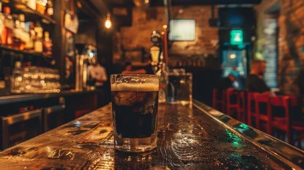 Fotobehang Rustic bar ambiance, a clear glass holding the rich layers of an Irish Car Bomb, dim lighting accentuating the unkempt charm © Paul