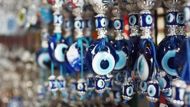 a bunch of blue evil eye keychains hanging on a shelf