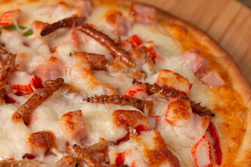 Pizza topped with bamboo worm edible insect crispy mixed with sausage slices, sweet pepper and mozzarella cheese, Fried insects are most widely sold street food in Thailand. Close-up, Selective focus