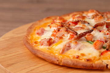 Pizza topped with bamboo worm edible insect crispy mixed with sausage slices, sweet pepper and mozzarella cheese, Fried insects are most widely sold street food in Thailand. Close-up, Selective focus