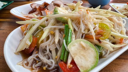Chinese noodle mix spicy papaya salad it called Tam Sua. Most popular food in Thailand.