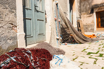 Fishing nets drying on pavement against wall on island of Hvar