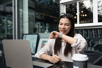 Caucasian or white woman using smart watch to communicate via talk and listen in the coffee shop...