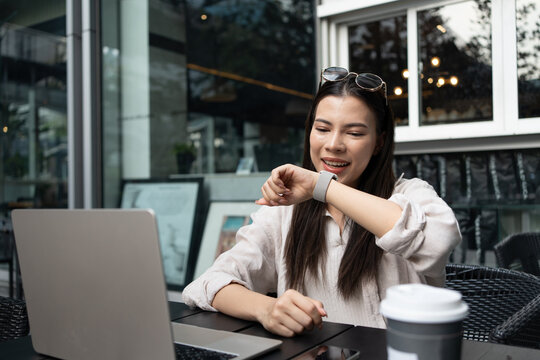 Caucasian or white woman using smart watch to communicate via talk and listen in the coffee shop after work. Beautiful white businesswoman working the city Bangkok, Thailand. 5G wireless technology.