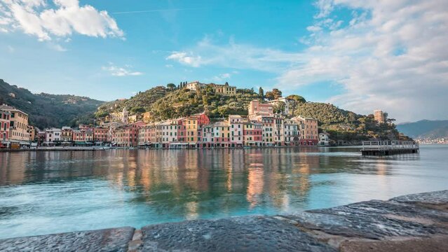 Motion time lapse over harbor of picturesque sunny Portofino as boat pulls in