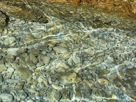 Stones pebbles in the clear sea water.