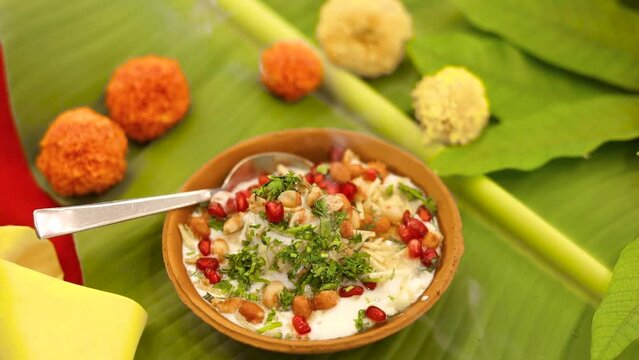 Indian Chaat Dahi Bhalle with Curd and Sweet Sauce on banana leaf with indian backdrop